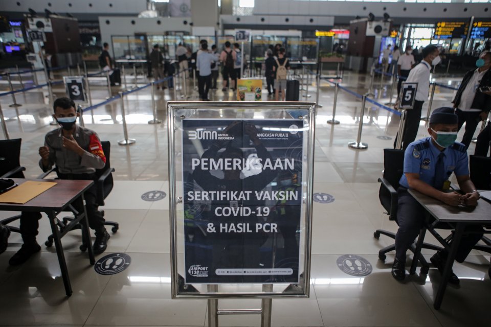 Petugas memeriksa surat vaksinasi dan hasil tes PCR calon penumpang pesawat sebelum melakukan penerbangan di Terminal 3 Bandara Internasional Soekarno Hatta, Tangerang, Banten, Senin (5/7/2021). Penumpang di daerah PPKM Level 1-2 diijinkan menggunakan rap