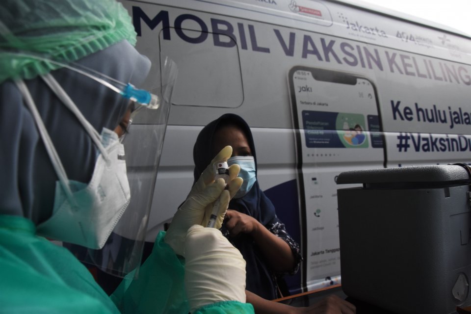 Petugas kesehatan menyuntikkan vaksin Sinovac kepada warga saat mobil vaksin keliling singgah di Kantor Kelurahan Cipedak, Jakarta, Selasa (13/7/2021). Dengan adanya mobil vaksinasi keliling itu, diharapkan target pemerintah untuk memvaksinasi 7,5 juta wa