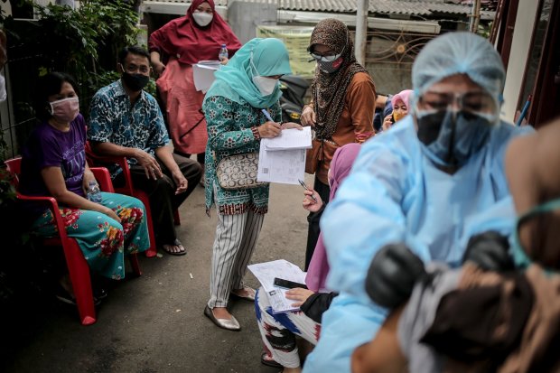 Sejumlah warga melakukan registrasi untuk menerima suntikan vaksin Covid-19 yang digelar dari pintu ke pintu (door to door) di Cijantung, Pasar Rebo, Jakarat Timur, Rabu (14/7/2021). 