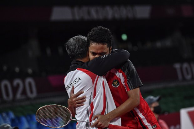 Pebulutangkis tunggal putra Indonesia Anthony Sinisuka Ginting (kanan) memeluk pelatihnya Hendry Saputra seusai mengalahkan tunggal putra Denmark Anders Antonsen dalam perempatfinal Olimpiade Tokyo 2020, Sabtu (31/7/2021). Ginting gagal melaju ke final O