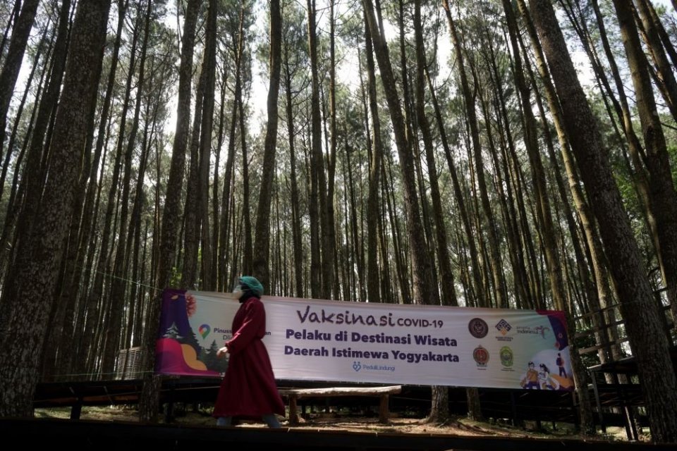 Vaksinator melintasi area hutan pinus saat vaksinasi COVID-19 untuk pelaku wisata di tempat wisata Hutan Pinus Mangunan, Dlingo, Bantul, D.I Yogyakarta, Rabu (28/7/2021). Dinas Pariwisata Bantul menargetkan sebanyak 2.000 pelaku wisata akan memperoleh vak