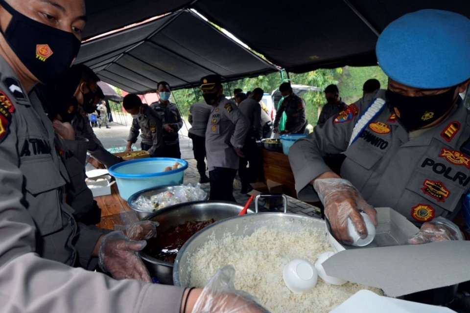 Sejumlah petugas kepolisian mengemas makanan ke dalam kotak di dapur umum Polda Lampung, Lampung, Jumat (6/8/2021). Sebanyak enam kabupaten/kota di Lampung masih menerapkan PPKM Level 4. ANTARA FOTO/Ardiansyah/foc.