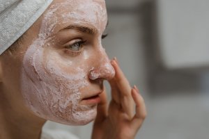 Ilustrasi perempuan sedang mengenakan masker kecantikan untuk merawat kesehatan kulit wajah
