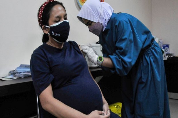 Petugas kesehatan (kanan) menyuntikkan vaksin Sinovac kepada ibu hamil di RSIA Tambak, Jakarta, Rabu (18/8/2021). Vaksinasi tersebut diadakan sekali dalam satu pekan dengan pembatasan maksimal 60 peserta guna melindungi ibu hamil dan janin dari infeksi CO