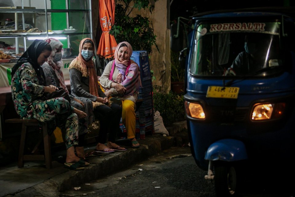 Pencari suaka asal Afghanistan bercengkrama di depan warung makan yang berlokasi tak jauh dari tenda yang didirikannya sebagai bentuk protes mereka di samping Kantor Komisi Tinggi PBB untuk Pengungsi (UNHCR), Kebon Sirih, Jakarta, Jumat, (27/8/2021). Sela