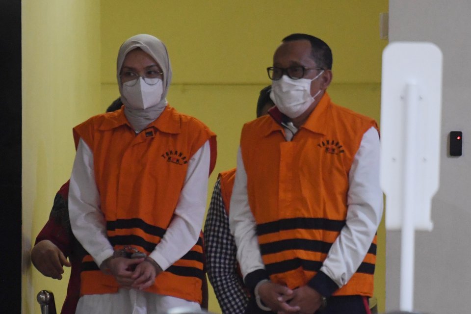 Bupati Probolinggo Puput Tantriana Sari (kiri) bersama suaminya yang juga anggota DPR dan mantan Bupati Probolinggo Hasan Aminuddin mengenakan rompi tahanan KPK usai diperiksa di gedung KPK, Jakarta, Selasa (31/8/2021) dini hari. KPK melakukan operasi tan