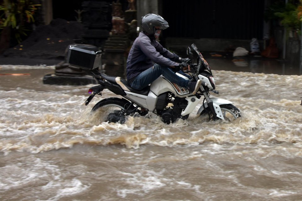 Pengendara motor menerobos banjir yang menggenangi kawasan Jalan Gunung Tangkuban Perahu, Kuta Utara, Badung, Bali, Kamis (9/9/2021). Hujan deras yang mengguyur wilayah Bali pada Kamis (9/9) dini hari tersebut menyebabkan jalur pariwisata di kawasan Kabup