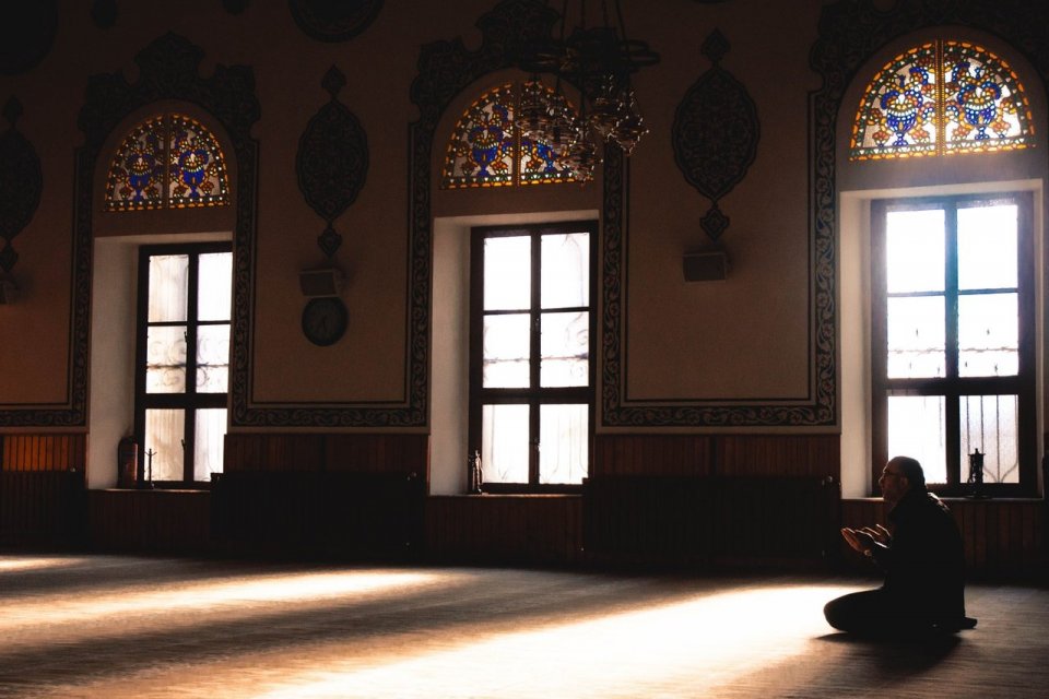 Ilustrasi seorang yang membaca surat Al Ikhlas di sebuah masjid
