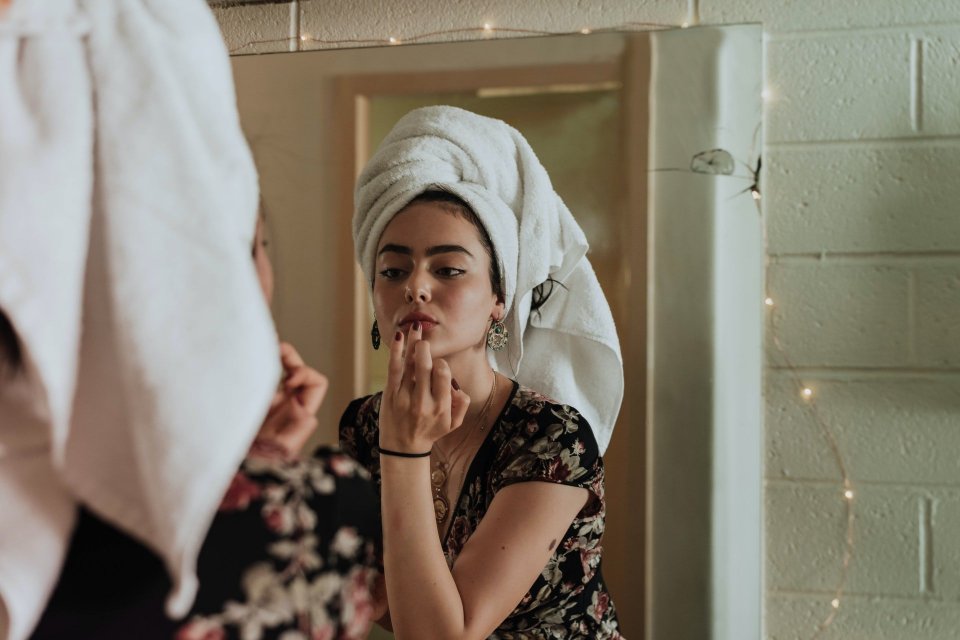 Ilustrasi seorang wanita menerapkan cara memutihkan wajah secara alami