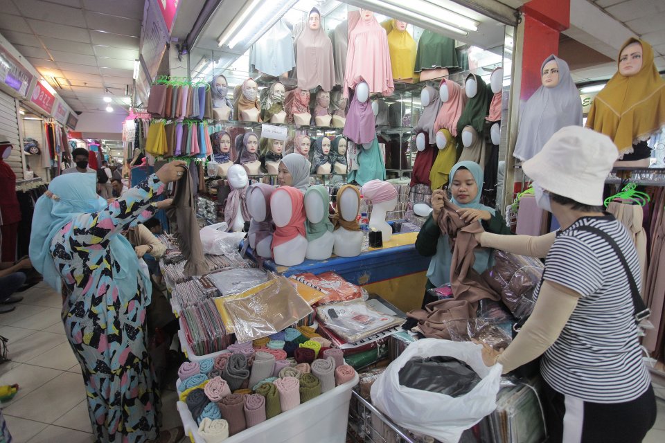 Pengunjung melihat produk busana muslim di salah satu kios di Pasar Tanah Abang, Jakarta, Sabtu, (9/10/2021). Pendapatan nasional adalah jumlah pendapatan yang diterima seluruh pelaku ekonomi dalam suatu negara selama satu tahun. Perhitungan pendapatan na