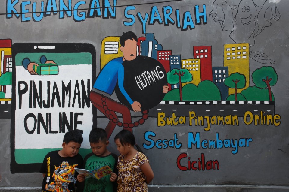 Sejumlah anak membaca bersama di dekat dinding bermural di kawasan Tempurejo, Surabaya, Jawa Timur, Selasa (7/9/2021). 