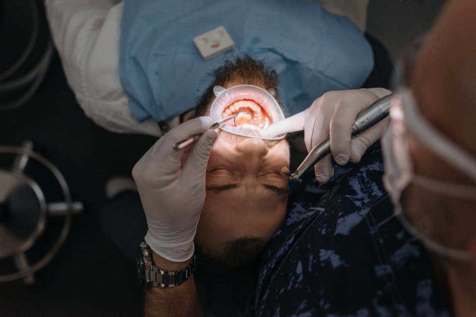 Ilustrasi orang yang sedang melakukan cara meredakan sakit gigi dengan bantuan dokter