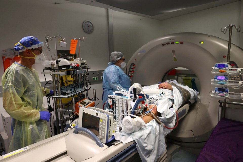 Staf medis mempersiapkan pasien yang membutuhkan unit pendukung kehidupan ECMO (extracorporeal membrane oxygenation) untuk pemeriksaan CT di Unit Perawatan Intensif (ICU) penyakit virus corona (COVID-19) dari klinik \"Klinikum Darmstadt\" di Darmstadt