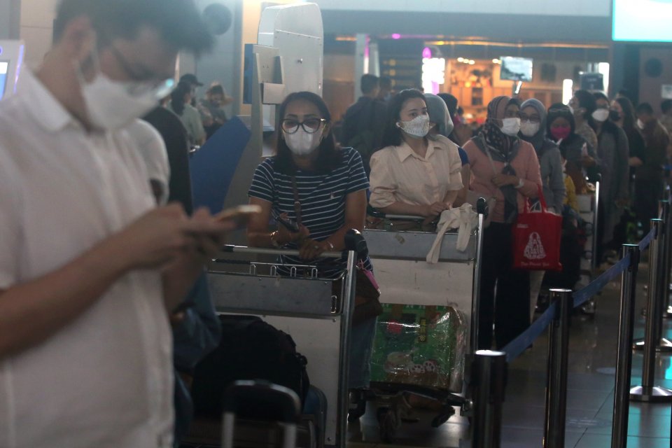 Calon penumpang pesawat mengantre untuk lapor diri di Terminal 3 Bandara Internasional Soekarno Hatta, Tangerang, Banten, Jumat (24/12/2021).
