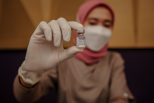 Petugas kesehatan menunjukkan vaksin booster saat penyuntikan vaksin di Mal Kota Kasablanka, Jakarta, Rabu (26/1/2022). Vaksin Booster yang disediakan adalah vaksin jenis Pfizer, berlaku bagi peserta yang sudah vaksin lengkap hingga dosis ke-2 dengan jeni