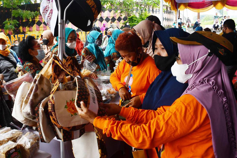 Pengunjung melihat berbagai produk kerajinan dan makanan olahan pada bazar UMKM di Madiun, Jawa Timur, Minggu (20/2/2022). Bazar yang diikuti puluhan pelaku UMKM tersebut bertujuan untuk membangkitkan perekonomian pada masa pendemi COVID-19.