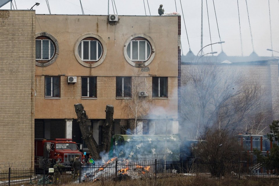 Sejumlah orang berseragam melempatkan berbagai benda ke api di depan gedung intelijen di unit Kementrian Pertahanan Ukraina, di Kyiv, Ukraina, Kamis (24/2/2022). ANTARA FOTO/REUTERS/Umit Bektas/FOC/djo