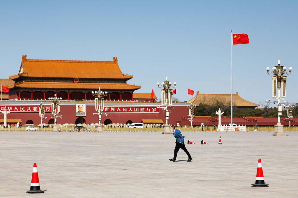 Carlos Garcia Rawlins Seorang pria berjalan menantang angin melewati bendera Tiongkok di Lapangan Tiananmen sebelum sesi pembukaan Konferensi Konsultatif Politik Rakyat Tiongkok (CPPCC) di Beijing, China, Jumat (4/3/2022).