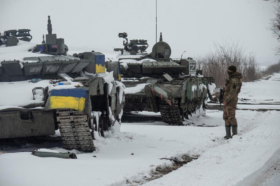 Rusia, Ukraina, simbol Z Seorang tentara Ukraina berdiri di tank Rusia yang ditangkap, satunya diwarnai dengan warna bendera nasional Ukraina dan yang lainnya dengan huruf "Z", di tengah invasi Rusia ke Ukraina, di utara Kharkiv, Ukraina, J