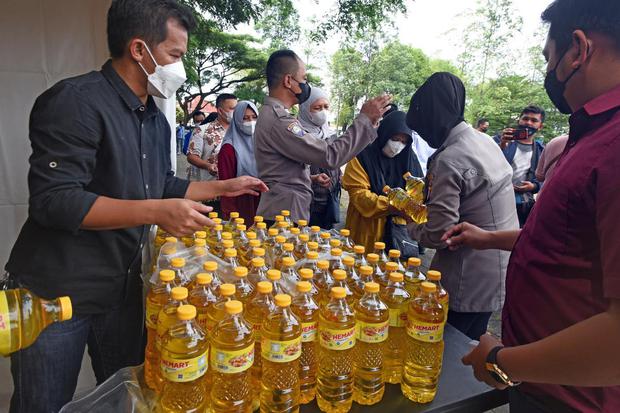 Sejumlah personel polisi membantu pedagang menjual minyak goreng kepada warga saat Operasi Pasar Minyak Goreng Murah di Alun-alun Serang, Banten, Rabu (9/3/2022). Operasi pasar yang digelar jajaran Polres Serang bersama pedagang itu menjual sembilan ribu 