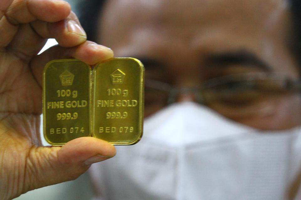 Pramuniaga menunjukkan emas untuk investasi atau batangan Antam di sebuah gerai emas di Malang, Jawa Timur, Kamis (10/3/2022). Pengusaha emas setempat mengatakan fluktuasi harga emas yang cenderung meningkat dan berada di kisaran Rp1.012.000 per gram akib