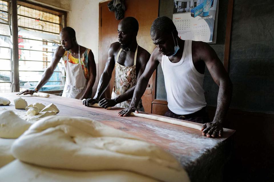 Francis Kokoroko menyiapkan adonan roti di toko roti Bethel Brothers di Accra, Ghana. Pemerintah Ghana bangkrut akibat utang luar negeri yang membengkak.