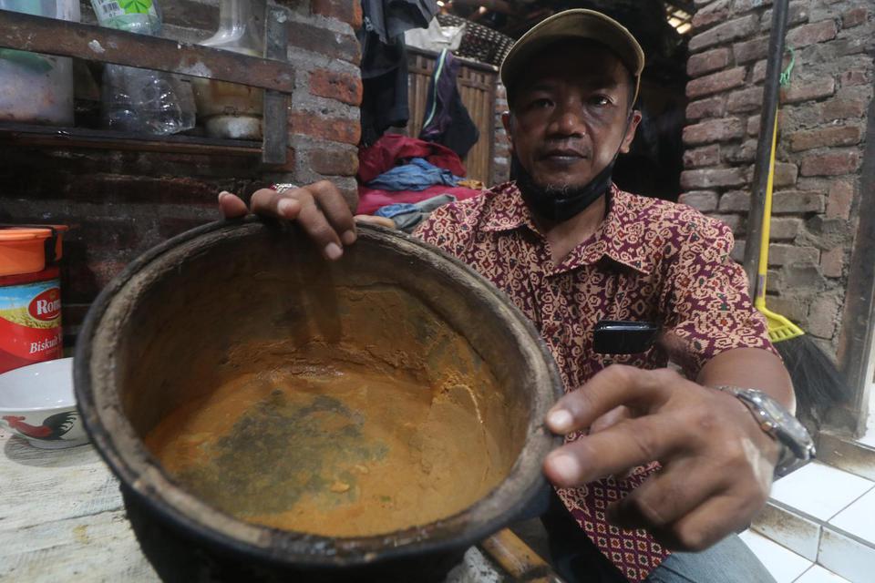 Warga memperlihatkan endapan dari air tanah yang tercemar di Kelurahan Bujel, Kota Kediri, Jawa Timur, Sabtu (19/3/2022). Sedikitnya 200 kepala keluarga di daerah tersebut mengeluhkan air sumur keruh dan berbau karena tercemar logam berat dari tanah uruk 