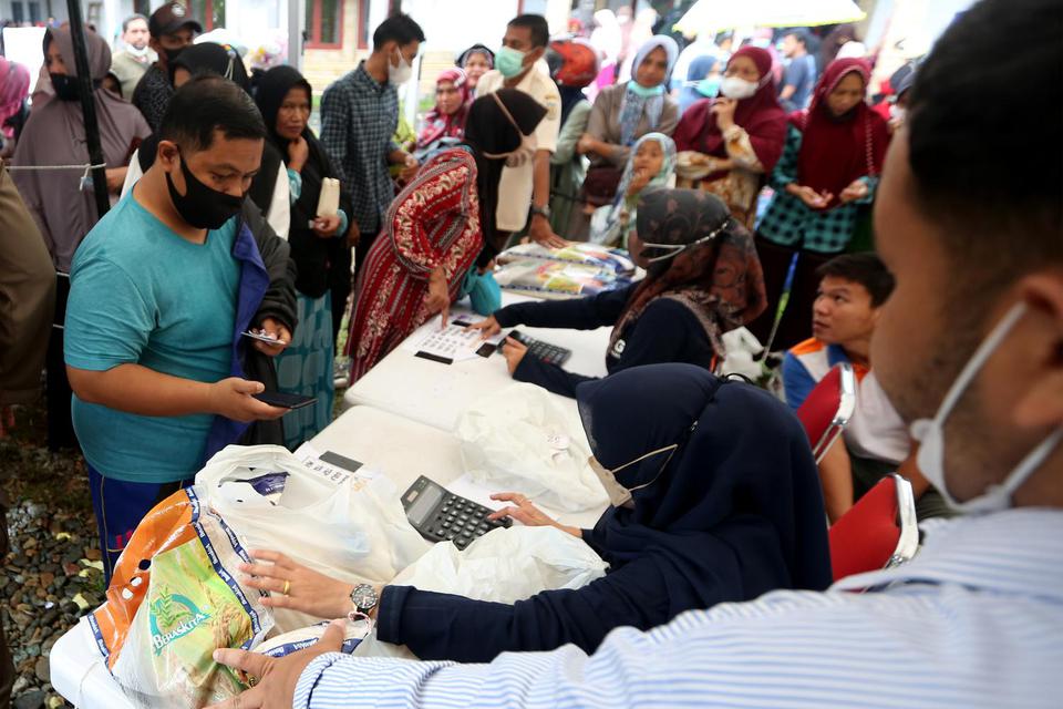 Warga antre membeli sembako dengan harga subsidi di pasar murah yang diselenggarakan Pemerintah di Banda Aceh, Aceh, Senin (21/3/2022).