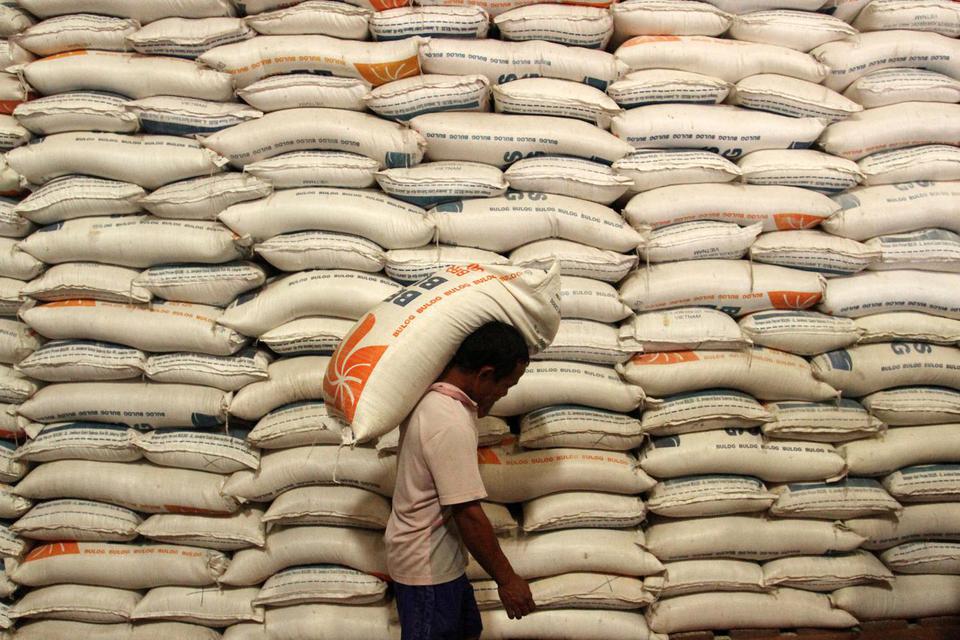 Pekerja memanggul karung berisi beras di gudang Perum Bulog Divre Sumatera Barat, Padang, Sumatera Barat, Senin (21/3/2022).
