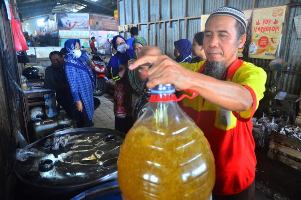 Pedagang melayani pembeli minyak goreng curah di Pasar Bitingan, Kudus, Jawa Tengah, Rabu (23/3/2022). 