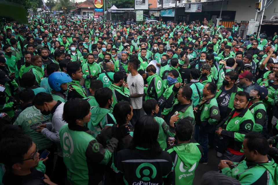 Pengemudi ojek online yang tergabung dalam Paguyuban Gojek Driver Jogjakarta (Pagodja) melakukan aksi damai di depan kantor Gojek, Umbulharjo, Yogyakarta, Kamis (24/3/2022). Dalam aksi itu mereka menuntut manajemen Gojek untuk mengembalikan tarif minimal 