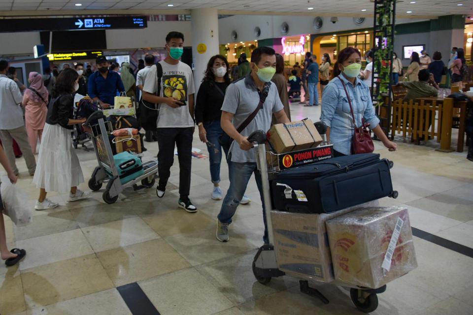 Sejumlah calon penumpang pesawat berjalan di area terminal keberangkatan Bandara Kualanamu, Deli Serdang, Sumatera Utara, Kamis (24/3/2022). 