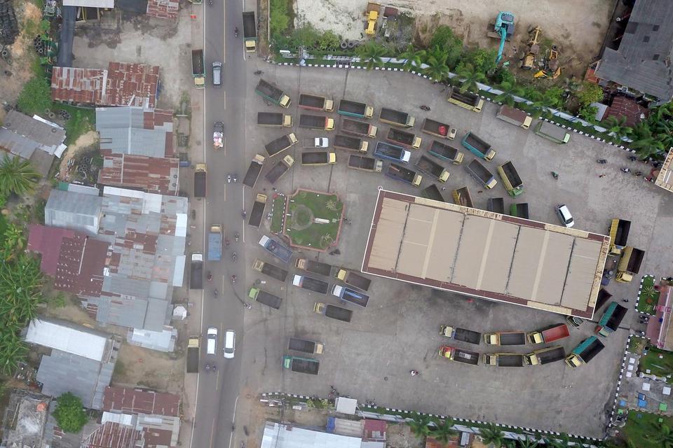 Foto udara sejumlah truk mengantre untuk mengisi bahan bakar solar bersubsidi di SPBU Paal Lima, Kota Baru, Jambi, Jumat (25/3/2022).