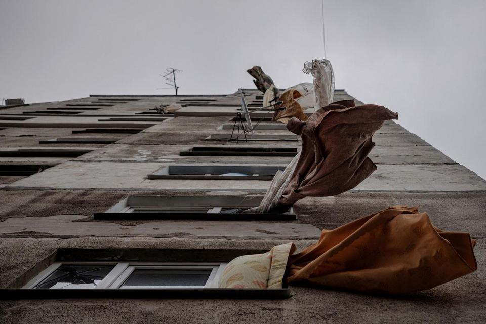 Gorden berkibar tertiup angin di sebuah bangunan rusak akibat penembakan di lingkungan yang sebagian besar telah ditinggalkan dan dibiarkan tanpa air, gas, dan pemanas saat serangan Rusia ke Ukraina berlanjut, di Kharkiv, Ukraina, Senin (28/3/2022). (Foto