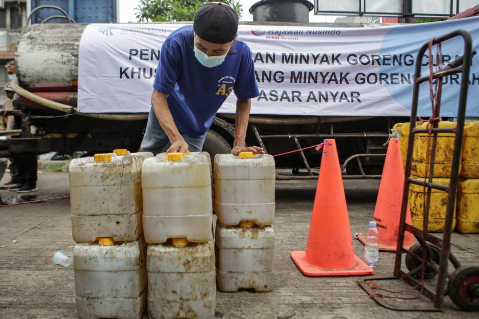 Pedagang membawa jeriken berisi minyak goreng curah saat pendistribusian di Pasar Anyar, Kota Tangerang, Banten, Selasa (29/3/2022). 
