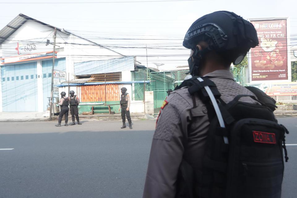 Polisi berjaga di area penemuan benda yang diduga bom di Solo, Jawa Tengah, Rabu (30/3/2022). Berdasarkan analisa dan evaluasi, pihak kepolisian memastikan jika benda mencurigakan yang ditemukan tersebut bukan benda yang membahayakan, namun hanya berisi s