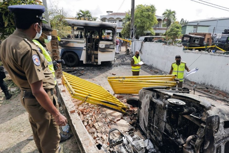 Petugas TKP Sri Lanka memeriksa kendaraan yang rusak setelah dibakar oleh demonstran di puncak jalan menuju kediaman Presiden Sri Lanka Gotabaya Rajapaksa, Jumat (1/4/2022)
