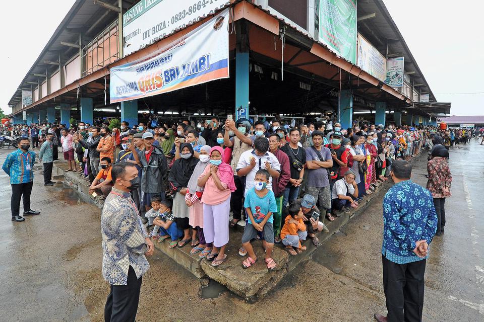 Sejumlah warga memadati bagian tepi salah satu bangunan saat menunggu kedatangan Presiden Joko Widodo di Pasar Modern Angso Duo, Jambi, Kamis (7/4/2022). Dalam kunjungannya ke pasar terbesar di Jambi itu, Presiden Joko Widodo juga menyerahkan bantuan moda