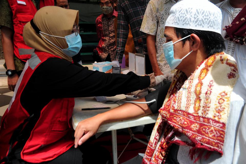Petugas kesehatan memeriksa tekanan darah salah satu jamaah sebelum melakukan ibadah di Masjid Agung, Palembang, Sumatera Selatan, Jumat (8/4/2022). Pemeriksaan kesehatan yang digelar oleh Palang Merah Indonesia (PMI) Kota Palembang ini berupa pemeriksaan