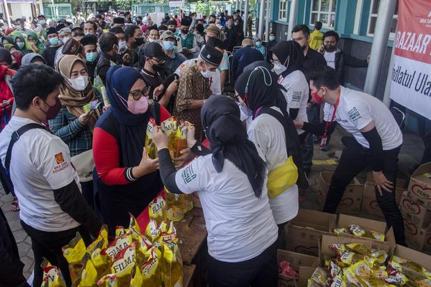 Warga antre membeli minyak goreng murah saat bazar di Gedung Dakwah PWNU Jawa Barat, Bandung, Jawa Barat, Rabu (13/4/2022).