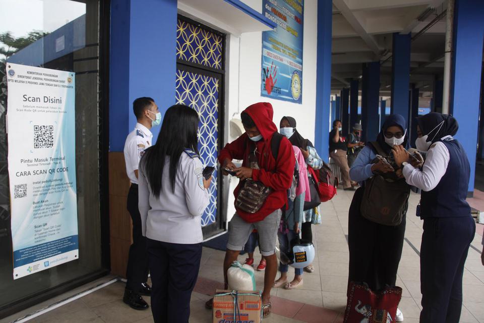 Petugas memeriksa sertifikat vaksin COVID-19 dan membagikan masker bagi penumpang yang tiba di Terminal Tirtonadi Solo, Jawa Tengah, Rabu (13/4/2022). Kegiatan tersebut sebagai penegakan protokol kesehatan (prokes) bagi penumpang terminal setempat menjela