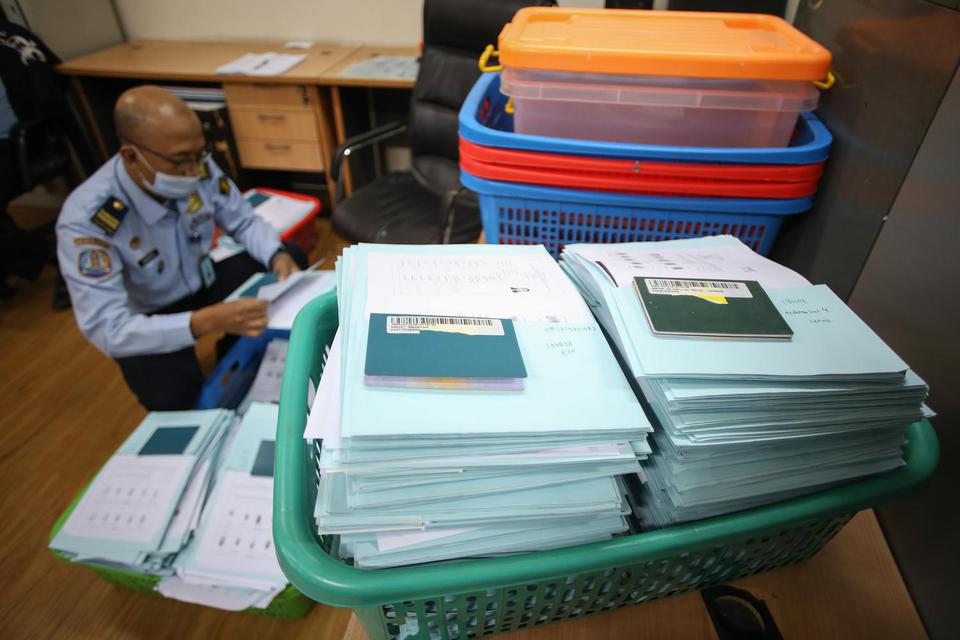 Petugas merapikan paspor di Kantor Imigrasi Jakarta Barat, Senin (18/4/2022). 