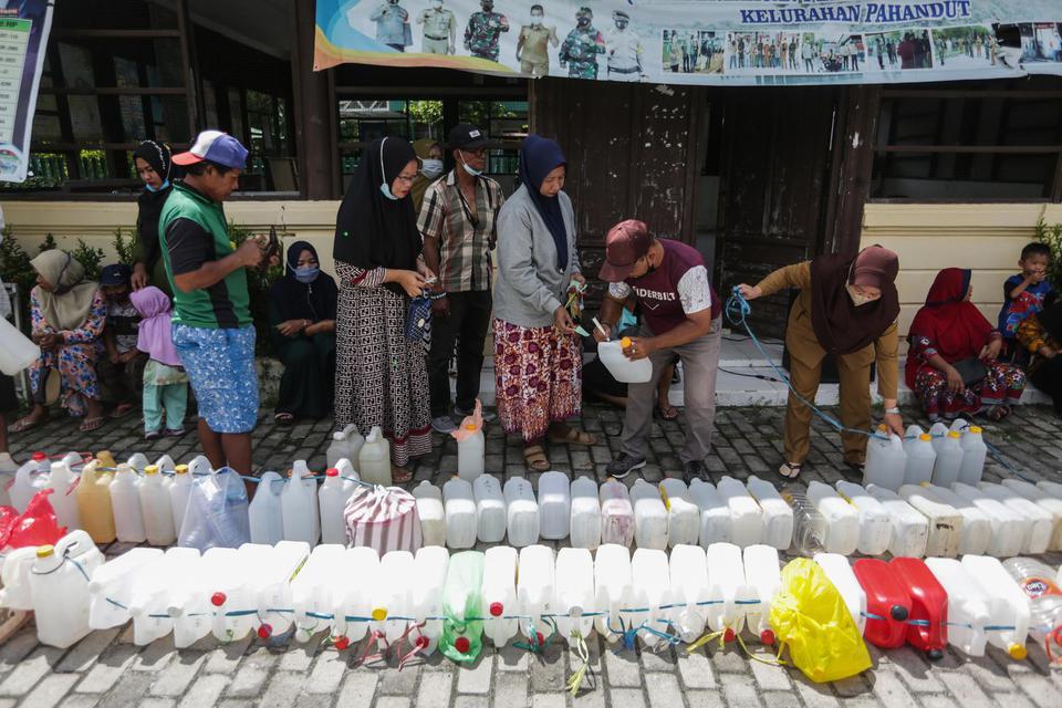 Warga menukarkan kupon kepada petugas untuk membeli minyak goreng curah saat operasi pasar murah minyak goreng di Kelurahan Pahandut, Palangka Raya, Kalimantan Tengah, Senin (18/4/2022). Pemkot Palangka Raya menggelar operasi pasar minyak tersebut selama 