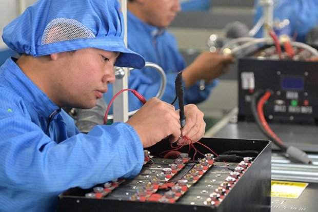 Seorang teknisi merakit baterai mobil lithium-ion di pabrik di provinsi Liaoning