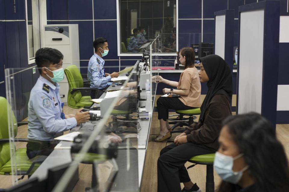 Petugas imigrasi merekam wajah pemohon pembuatan paspor di Kantor Imigrasi Kelas I Khusus Batam, Batam Centre, Batam, Kepulauan Riau, Selasa (19/4/2022). 