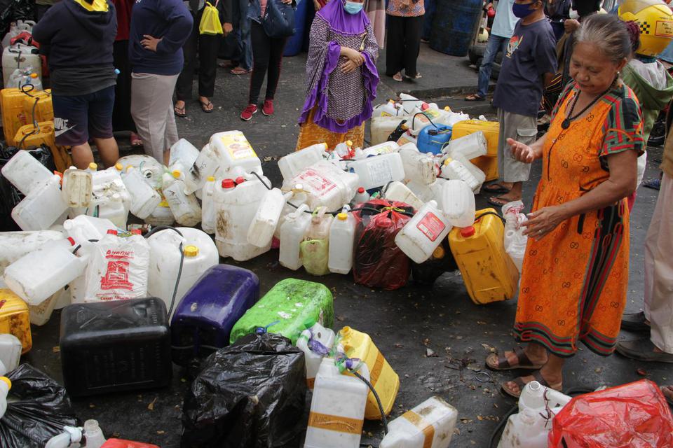 Warga menderetkan jerigen saat mengantre untuk membeli minyak goreng curah di salah satu distributor di Makassar, Sulawesi Selatan, Selasa (19/4/2022). 