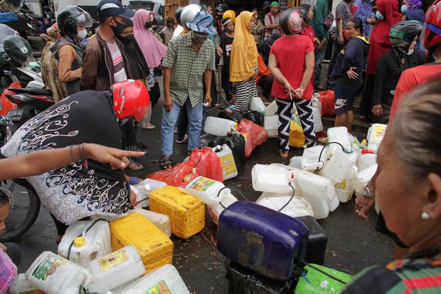 Warga menderetkan jerigen saat mengantre untuk membeli minyak goreng curah di salah satu distributor di Makassar, Sulawesi Selatan, Selasa (19/4/2022). Warga setempat lebih memilih membeli minyak goreng curah seharga Rp15.500 per kilogram meskipun harus m