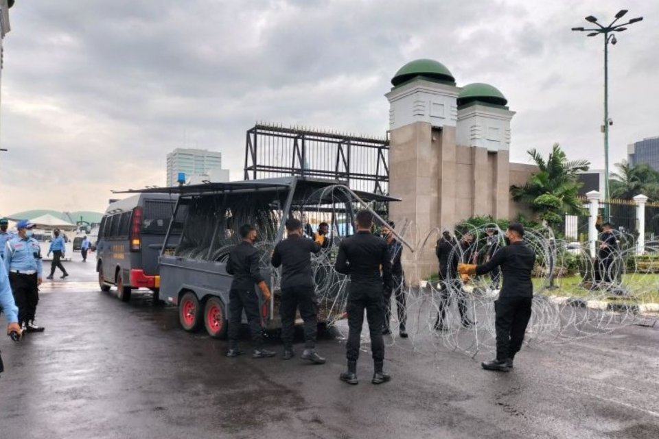 Polisi memasang kawat duri di depan Gedung DPR/MPR/DPD RI, senayan, Jakarta Pusat, Kamis (21/4/2022). (ANTARA/Walda)