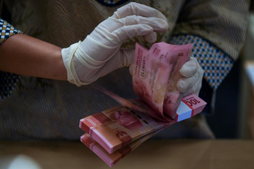 Teller menghitung uang di Bank BNI, Jakarta, Kamis (21/4/2022). 