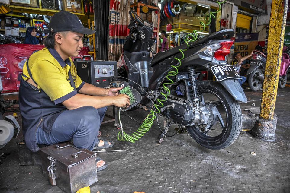 Montir memperbaiki sepeda motor di bengkel di Jakarta, Selasa (26/4/2022). Menjelang mudik Lebaran sejumlah bengkel kendaraan bermotor kebanjiran pelanggan, dan pelaku usaha tersebut memperkirakan omset bengkel motor naik 50 hingga 70 persen daripada hari
